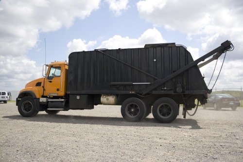 Man and van loading waste near a busy junction